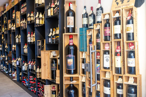 SIENA, ITALY - Aug 24, 2020: Siena, Toscana-Italy - 27.08.2020: A specialty wine store in Italy with many different types of wine displayed on shelves and in their original boxes. - Фото, изображение
