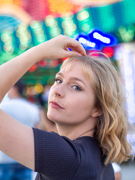 A vertical portrait of a young blonde female at an amusement park - 写真・画像