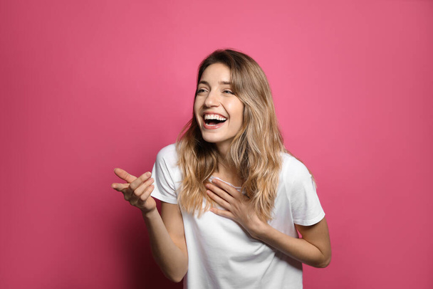 Cheerful young woman laughing on pink background - Fotografie, Obrázek