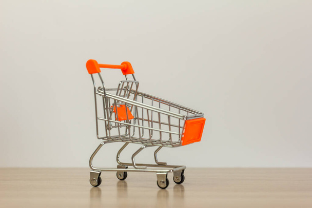 Small shopping cart on a light background, copy space, shopping concept - Foto, immagini