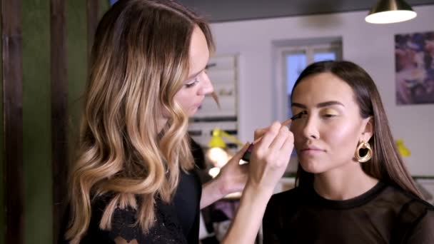 Make-up-Artist Make-up für attraktive junge asiatische Frauen in Schönheitssalon - Filmmaterial, Video