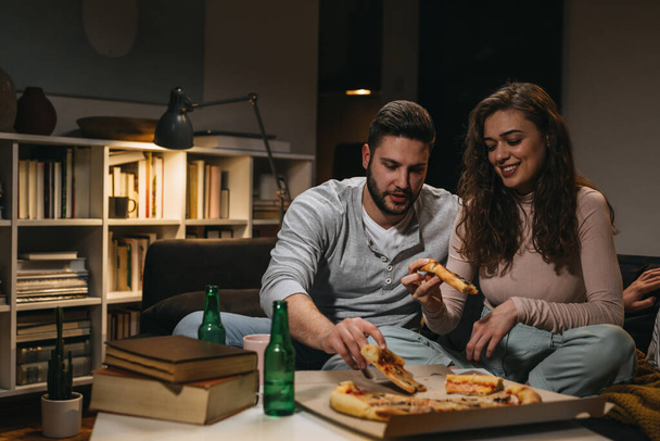 friends eating pizza while studying together at home - Foto, Imagen