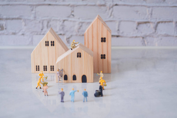 Engineering people and architecture miniature workers team working on construction helping build and repairing house on blue background.Teamwork business and real estate concept with copy space. - Photo, Image