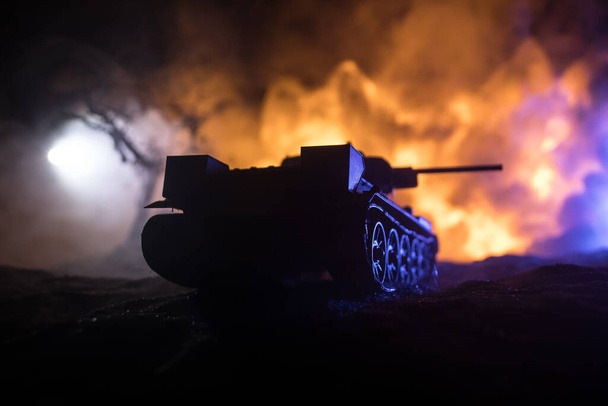 Έννοια πολέμου. Στρατιωτικές σιλουέτες καταπολέμηση σκηνή στο φόντο ομίχλη του πολέμου ουρανό, Στρατιώτες του Παγκοσμίου Πολέμου Σιλουέτα κάτω από συννεφιά Skyline τη νύχτα. Θωρακισμένο όχημα σκηνή αγώνα. Επιλεκτική εστίαση - Φωτογραφία, εικόνα