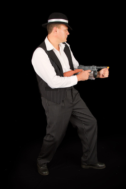 Dangerous gangster with 1920 style clothes standing with gun - 写真・画像