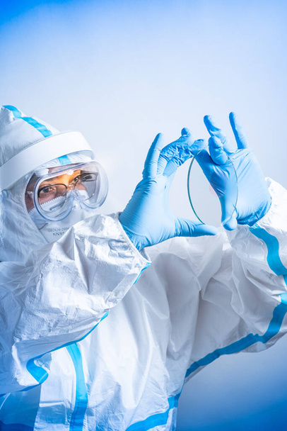 Female microbiologist or lab bio technician holding glass microscope slides with blood positive new strain or mutation Coronavirus. New variant found, new COVID-19 pandemic wave. - Φωτογραφία, εικόνα