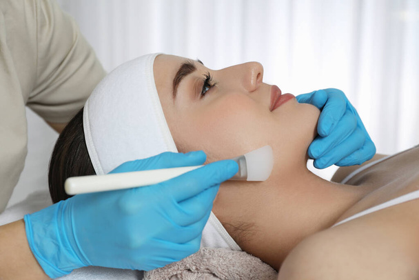 Young woman during face peeling procedure in salon - Photo, image