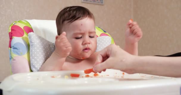 Mom feeds the boy with a spoon and hand, family food and parenthood concept. first complementary foods and self-feeding - Footage, Video