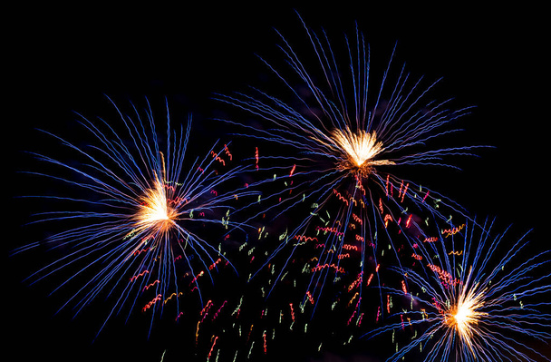 Fényes ünnepi tűzijáték az éjszakai égbolt ellen. Tűzijáték Tüzes virágok az ünnep alatt. - Fotó, kép