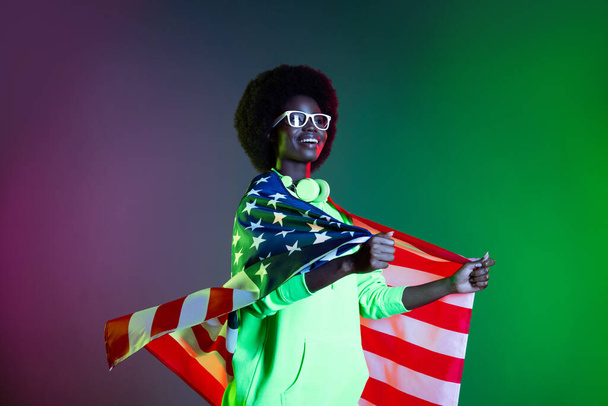 Photo of disco 80s lady wrapped american flag wear earphones specs sweatshirt isolated gradient green neon background - Foto, Imagen