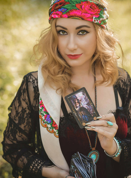 Çingene ruhu Tarot kartları, mumları ve sihirli topuyla tarlada, yaşam tarzında, öngörülerinde, Cadılar Bayramı 'nda kostüm için fikirleri olan Boho kadını. - Fotoğraf, Görsel