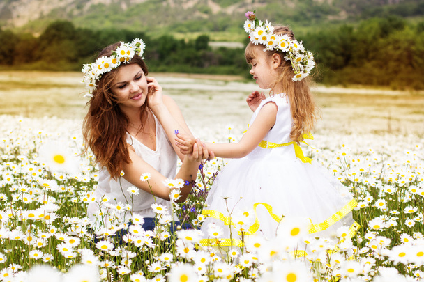 Mother with her child playing in camomile field - Foto, Imagen