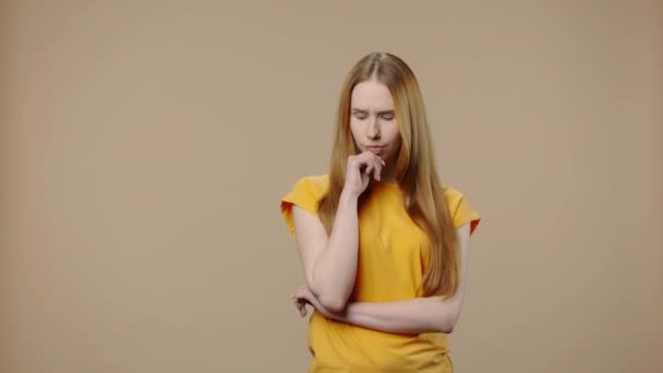 Portrait of beauty model is thinking about something and then happy that an idea coming to her. Young girl with long hair poses on brown studio background. Close up. Slow motion ready 59.94fps. - Πλάνα, βίντεο