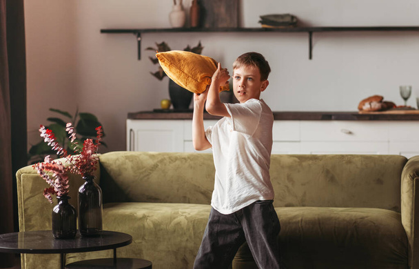 Un adolescente che gioca un gioco con un cuscino nella stanza - Foto, immagini
