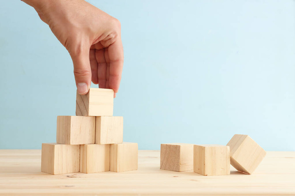 Hand arranging wood block stacking as chart or ladder. concept for growth and success - Photo, image