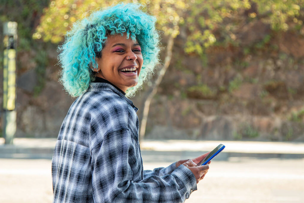 девушка с мобильным телефоном смеется вслух - Фото, изображение