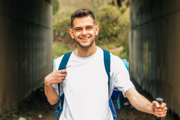 giovane uomo sorridente con bastoni da trekking - Foto, immagini