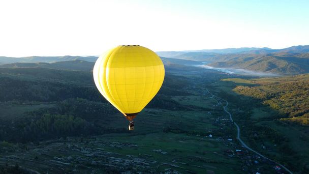 A balloon flies over the green mountains - Photo, Image