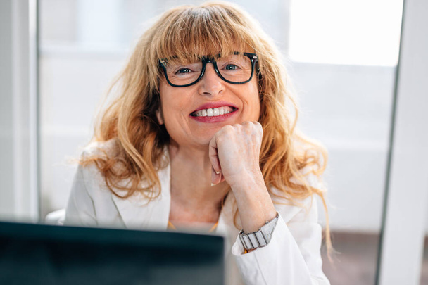 portrait of smiling businesswoman with glasses and computer - Photo, Image