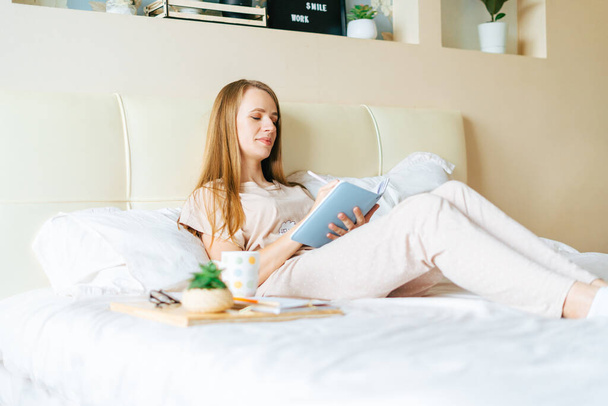 Blondi nainen sängyssä kirjan kanssa - Valokuva, kuva