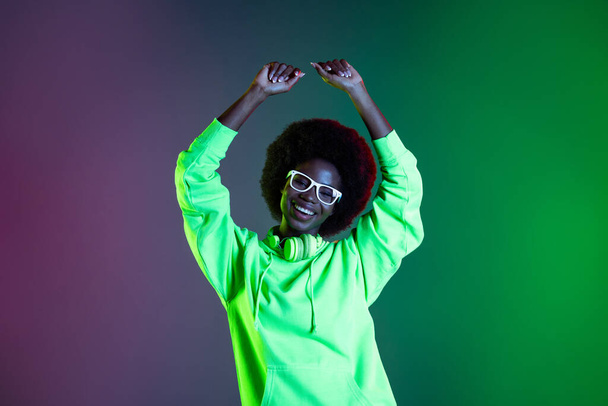 Photo of funny sweet dark skin woman wear sweatshirt headphones eyeglasses dancing isolated gradient background - Zdjęcie, obraz