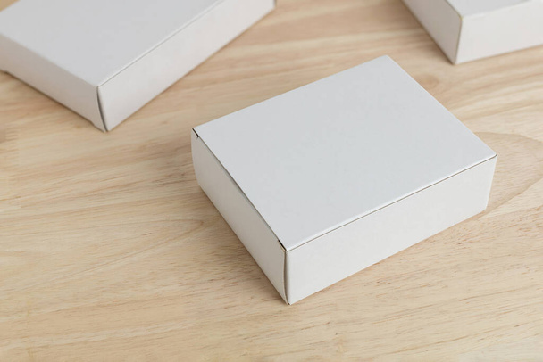 біла паперова коробка на дерев'яному столі для маскування порожнього шаблону
 - Фото, зображення