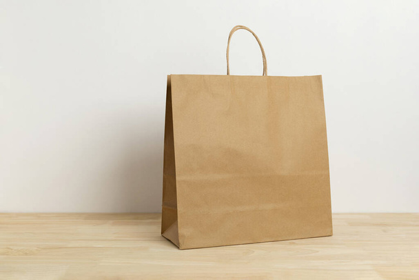 brown paper bag on wooden table for mockup blank template - Fotoğraf, Görsel
