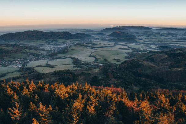 Awakening of nature on a new sunny day, when the fog evaporates and disappears from the valley and orange light falls there and awakens the biodiversity of the landscape to life. Excitation beam. - Fotoğraf, Görsel