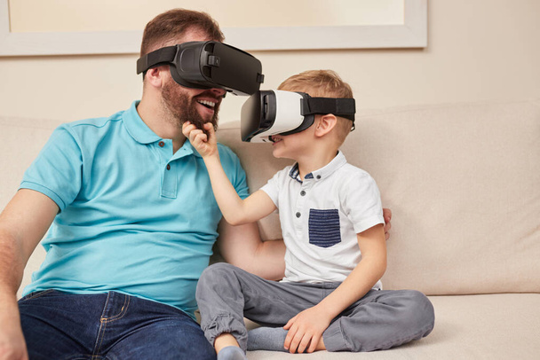 Father and son in VR goggles having fun together - 写真・画像