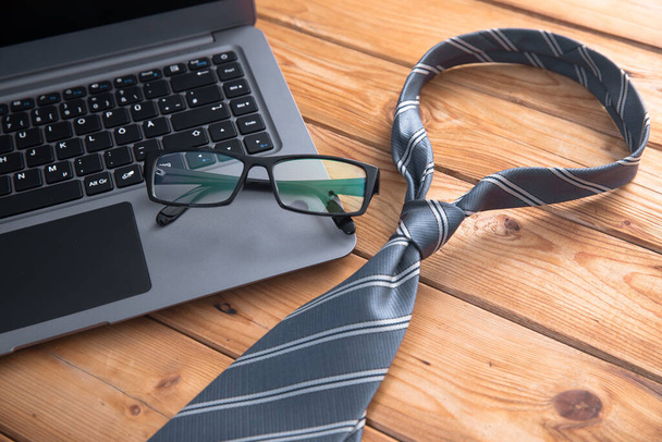 glasses on laptop and tie on the wooden tabl - Fotografie, Obrázek