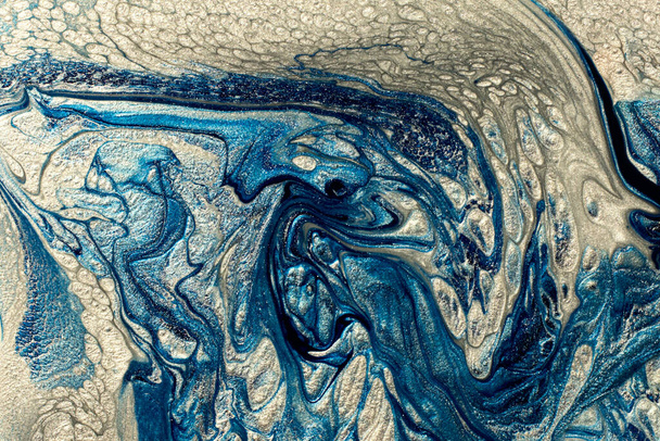 Belles taches bleues et argentées scintillantes de vernis à ongles liquide à la texture pétillante, ressemble à l'onde océanique.. - Photo, image