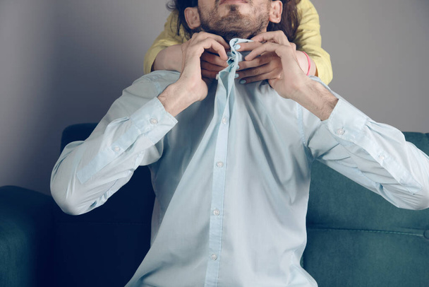 wife strangles husband sitting on couch - Φωτογραφία, εικόνα