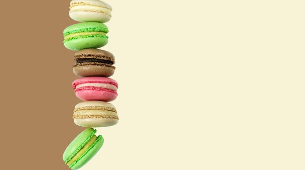 Multicolored macarons on chocolate brown and vanilla background - Foto, immagini