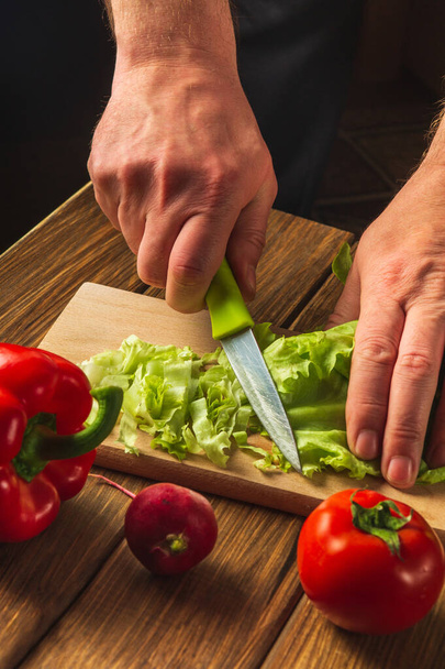 Salat kochen in der Restaurantküche. Chef ist hautnah geschnittenes Salatgemüse. Gemüse für eine Salatdiät. - Foto, Bild