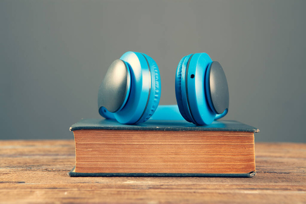 Concepto de audiolibro. libros y auriculares en madera la mesa - Foto, imagen