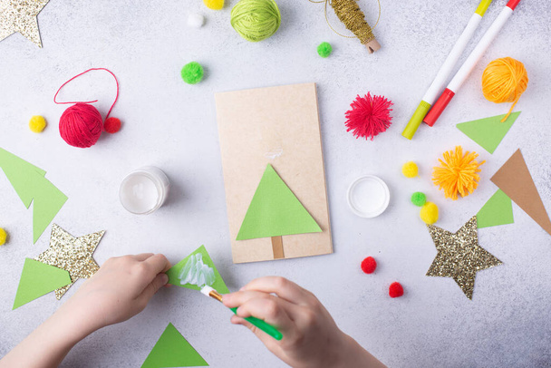 The child makes a greeting card Christmas paper collage. Children art project craft for kids - 写真・画像