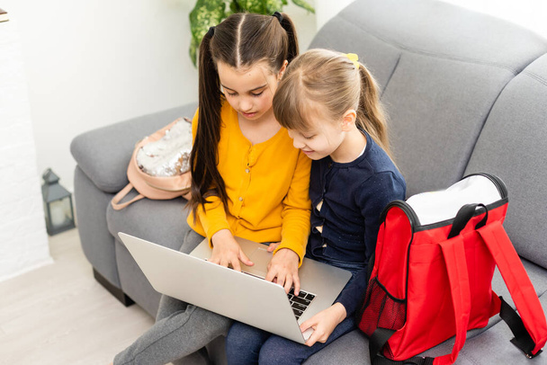 Two cute child girls using laptop together with fun and happiness - Φωτογραφία, εικόνα