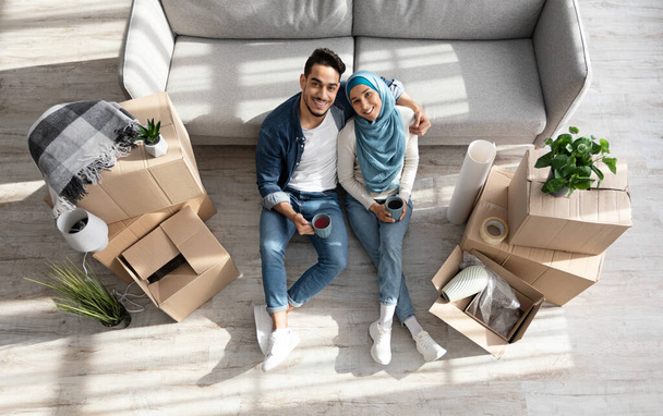 Amare marito e moglie seduti sul pavimento in una nuova casa - Foto, immagini