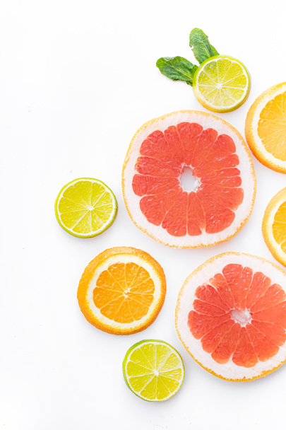 Citrusvruchten op een witte ondergrond worden gesneden. Gekleurde vruchten. De citrusfamilie. citrus gesneden lay-out bovenaanzicht op een witte achtergrond. Een artikel over gezond eten. Keto dieet. Groenten en fruit. - Foto, afbeelding
