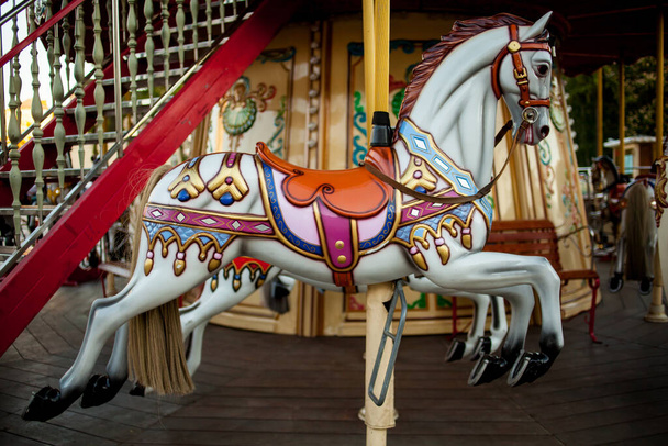 Retro carousel white, black horse. Old wooden horse carousel. Carousel Horses on vintage, retro carnival cheerful walk. CloseUp of colorful carousel with horses. - Photo, Image