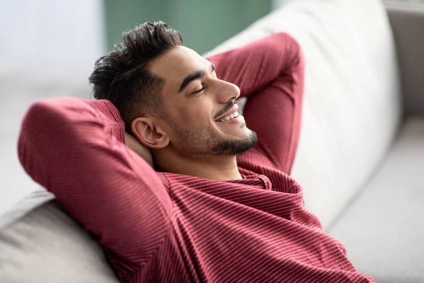 Closeup of peaceful muslim guy reclining on couch at home - Photo, Image