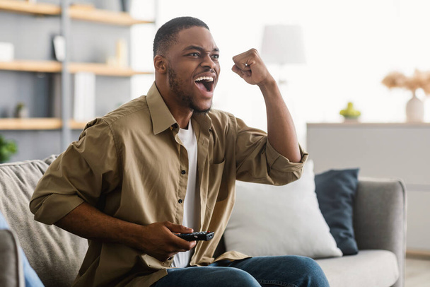 Joyful Black Guy Watching Sports Game On TV Shouting Indoors - Foto, Bild