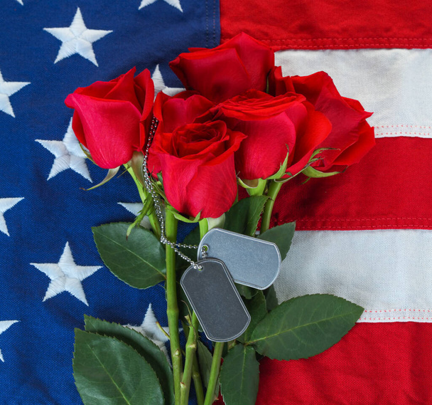 Αμερικανική σημαία με τριαντάφυλλα και λευκές στρατιωτικές ετικέτες σκύλων - Φωτογραφία, εικόνα