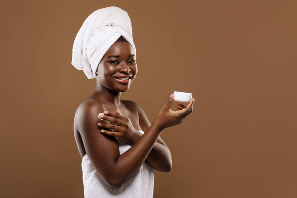 Self-Care Concept. Beautiful Black Lady With Towel On Head Applying Moisturising Cream - Foto, immagini