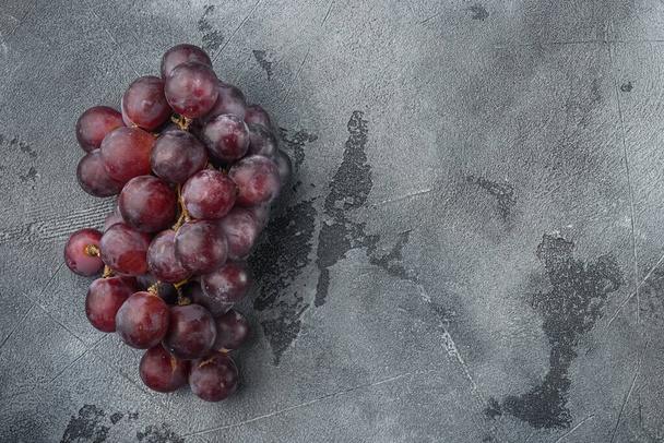 Finest natural home bunch of grapes set, dark red fruits, on gray stone background, top view flat lay, with copy space for text - 写真・画像
