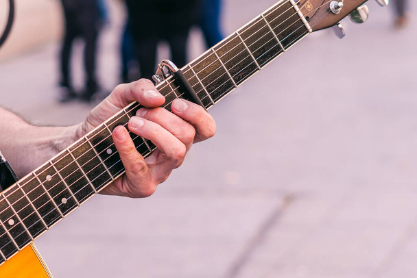 Dedos de un guitarrista de cerca tocando un acorde en el cuello de una guitarra - Foto, imagen