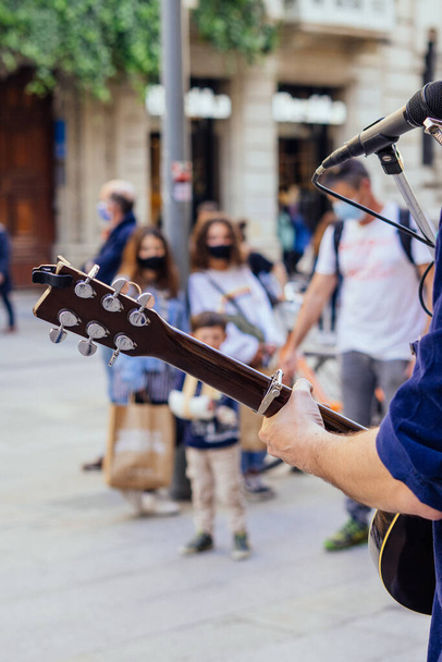 Barselona, İspanya - 3 Nisan 2021. Barcelona 'da arkasını dönüp gitar çalan bir sokak müzisyeni. - Fotoğraf, Görsel