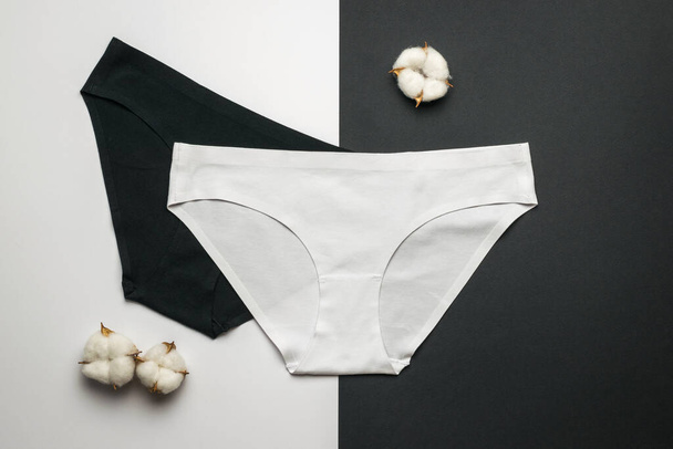 Black and white panties for women and cotton on a white and black background. Lingerie. Flat lay. - Photo, Image