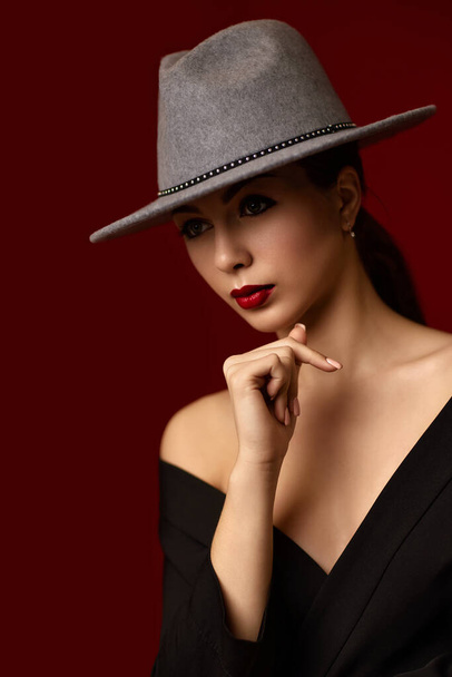 portrait of fashionable beautiful girl on red bakground. - Foto, afbeelding