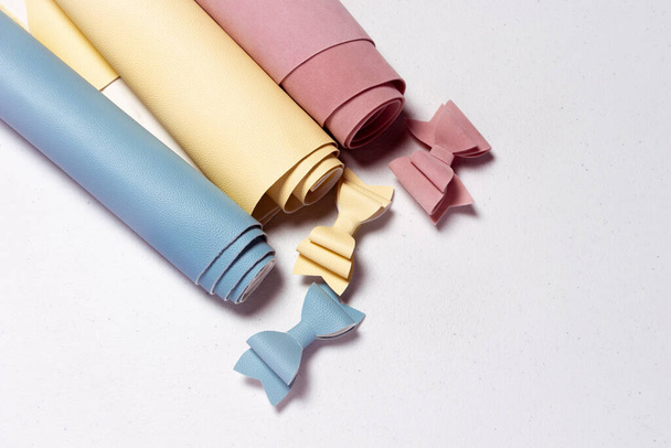 pastel maniquí de color y rollos de cuero real con arcos de colores a juego - Foto, Imagen